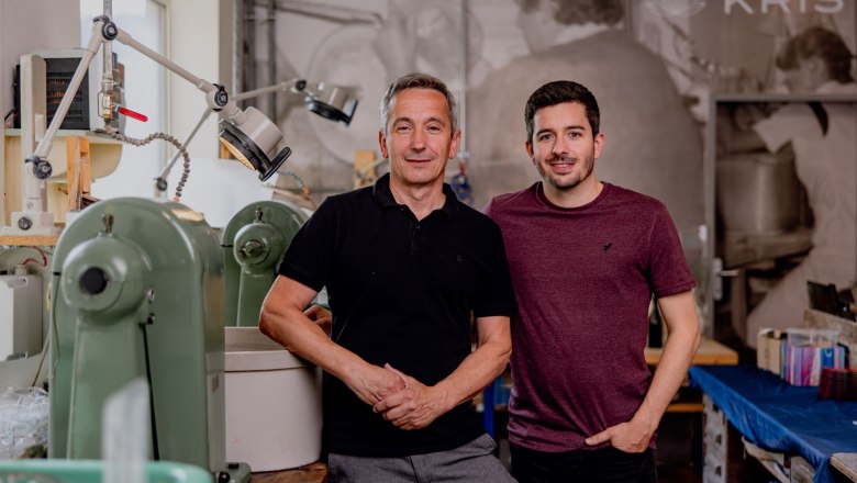 KRISTALLIUM glas.erleben., © Waldviertel Tourismus, Matthias Streibel Zwei Männer stehen in einer Werkstatt mit Maschinen im Hintergrund.