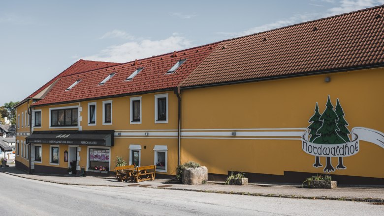 Gelbes Geb&auml;ude mit rotem Dach und Aufschrift 'Nordwaldhof'.