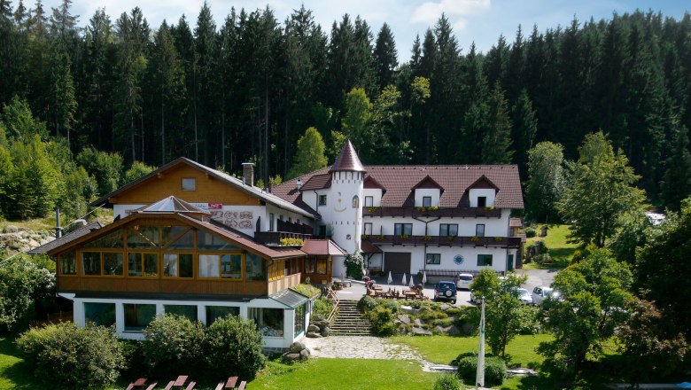 M&auml;rchenhotel Waldpension Nebelstein umgeben von Wald und Wiese.