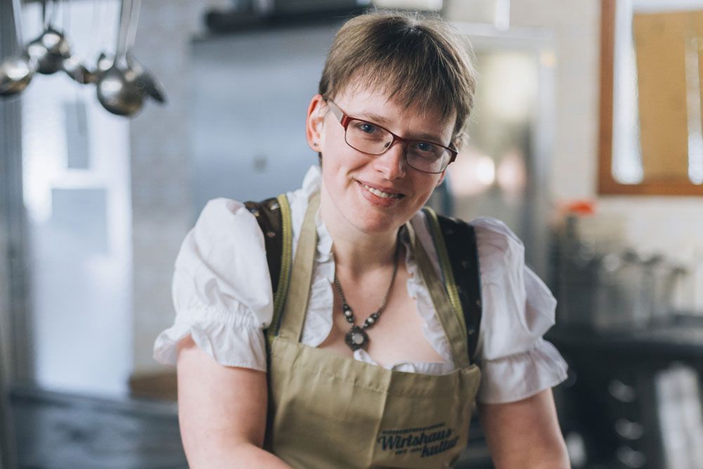 Frau in traditioneller Kleidung in einer Küche.