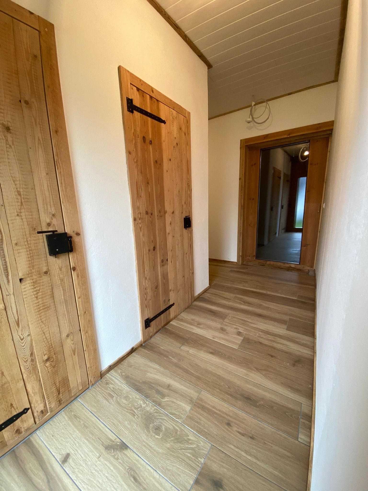 Ein Flur mit Holztüren und Holzboden.