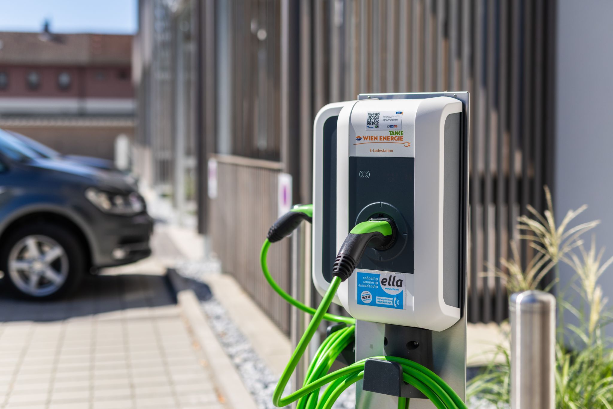 Eine E-Ladestation von Wien Energie mit grünem Kabel im Freien.
