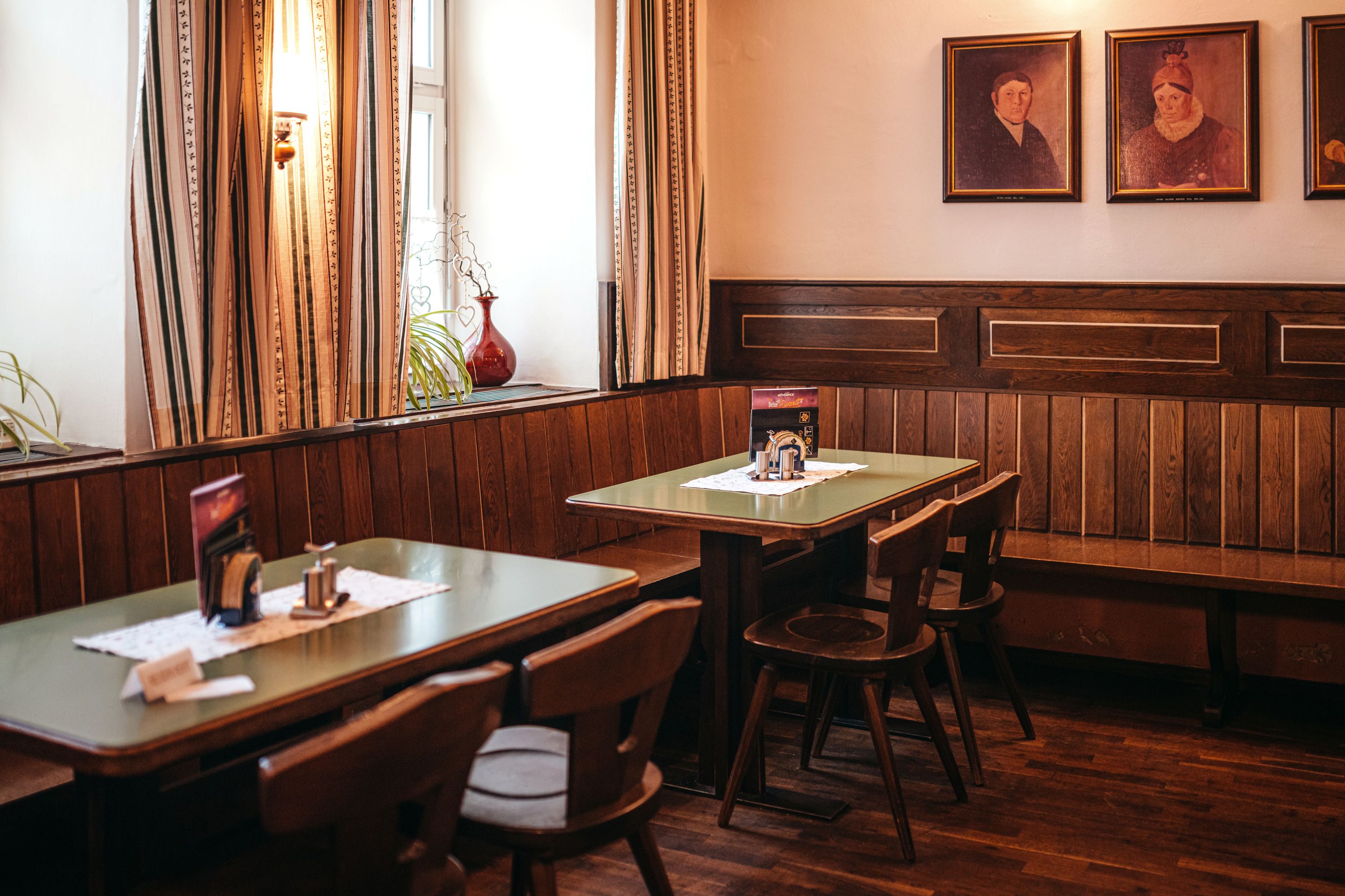 Traditionelle Stube mit Holzmöbeln und Gemälden an der Wand.