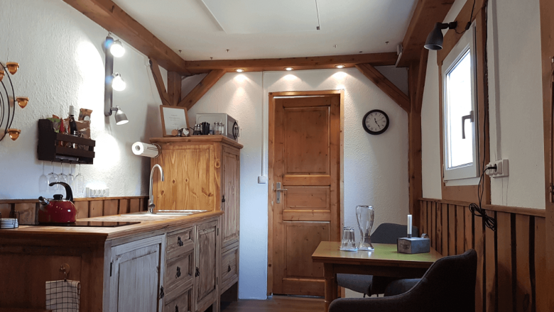 K&uuml;che mit Cerankochfeld, K&uuml;hlschrank und Mikrowelle im Tiny House Living Legends, &copy; Ederm&uuml;hle