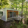 Modernes Baumhaus mit Terrasse im Wald.