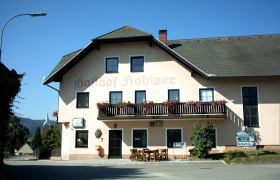Ein traditioneller Gasthof mit Balkon und Blumenschmuck, beschriftet mit 'Gasthof Hobiger'.