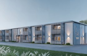 Modernes zweist&ouml;ckiges Geb&auml;ude mit Holzverkleidung und beleuchteten Fassaden bei D&auml;mmerung.