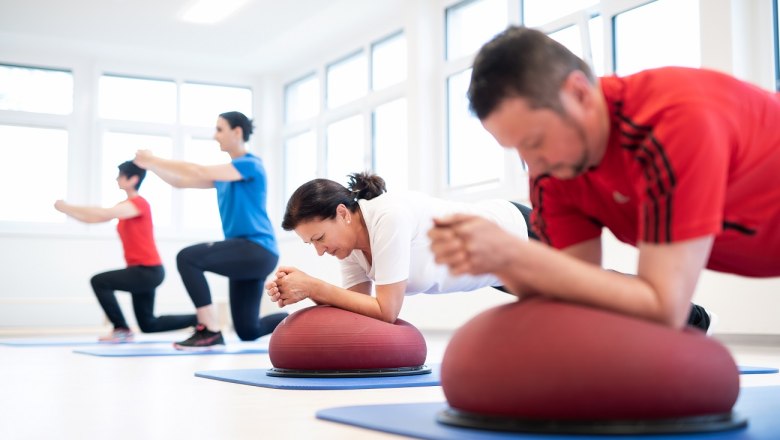 Personen beim Kraft- und Sensomotoriktraining auf Matten.