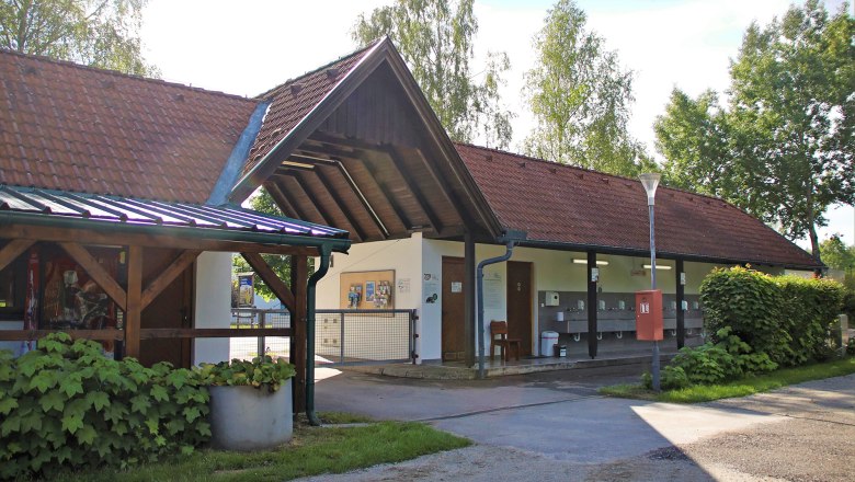 Au&szlig;enansicht eines Geb&auml;udes mit roten Ziegeld&auml;chern und Waschbecken im Freien.