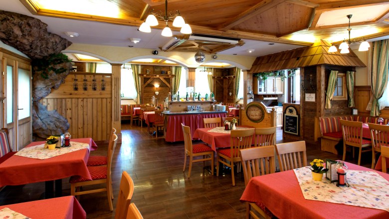 Ein gem&uuml;tliches Hotelzimmer mit Holzboden, einem gro&szlig;en Bett, einem Schreibtisch und einem dekorativen Baldachin an der Decke.