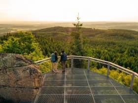Zwei Frauen stehen auf der Aussichtsplattform am Nebelstein und genießen den weiten Ausblick über die Waldlandschaft