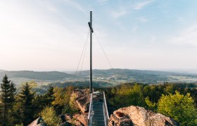 Aussichtsplattform mit Gipfelkreuz auf dem Nebelstein, umgeben von Wald und H&uuml;geln im Waldviertel.
