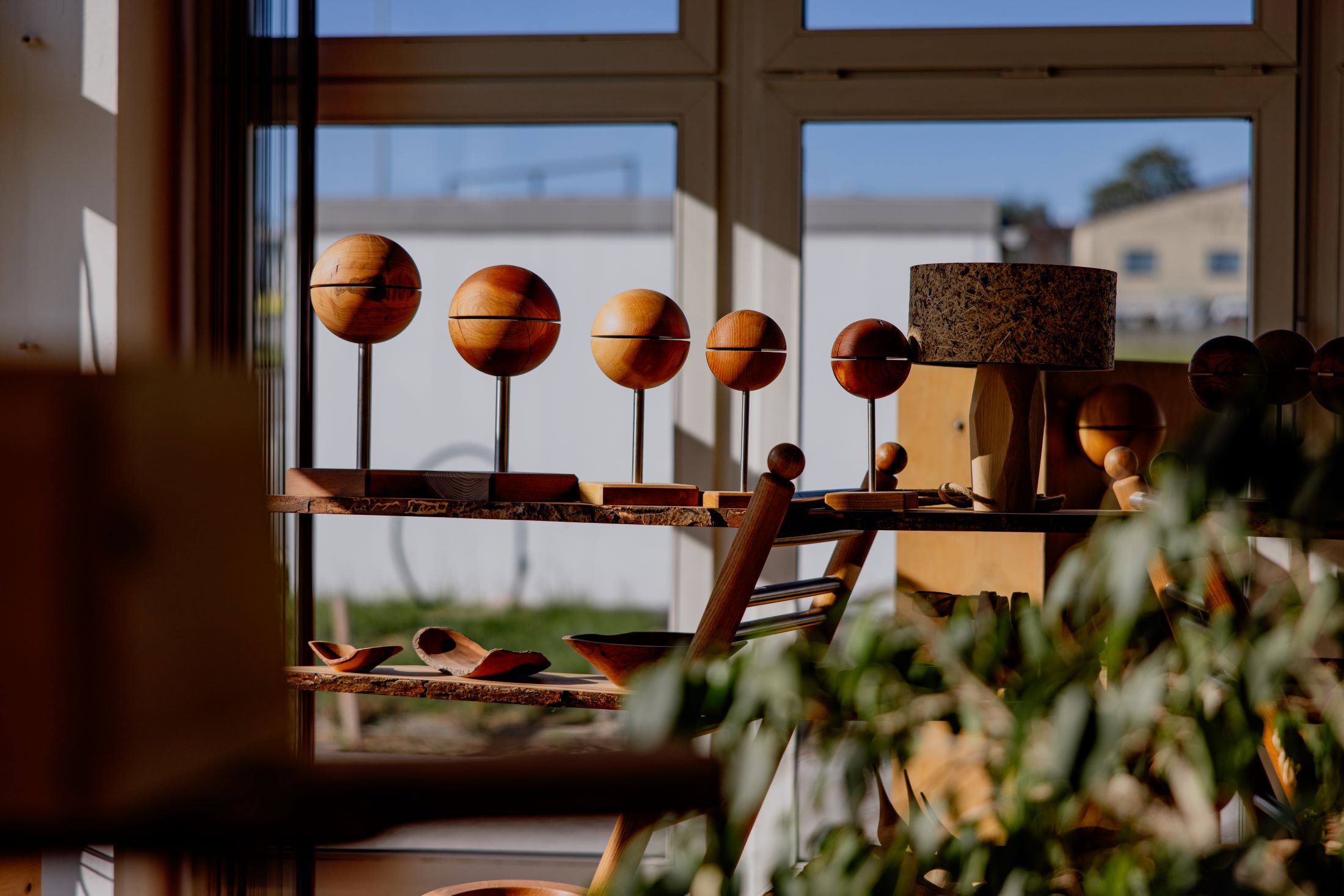 Holzkunstwerke in einem sonnigen Raum mit Fenstern.