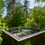 Baumhaus mit Terrasse in einem Wald.