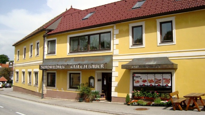 Gelbes Geb&auml;ude mit rotem Dach und Schildern 'Nordwaldhof' und 'Fleischhauerei'.
