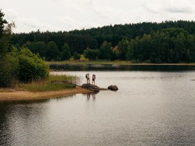 Zwei Frauen stehen am Ufer des Brandteichs und genie&szlig;en die Landschaft