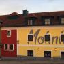 Fassade des Bergwirt Schrammel & Mohnhotel mit rotem und gelbem Anstrich.