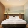 Modernes Apartment mit Doppelbett, minimalistischer Dekoration und sanfter Beleuchtung.