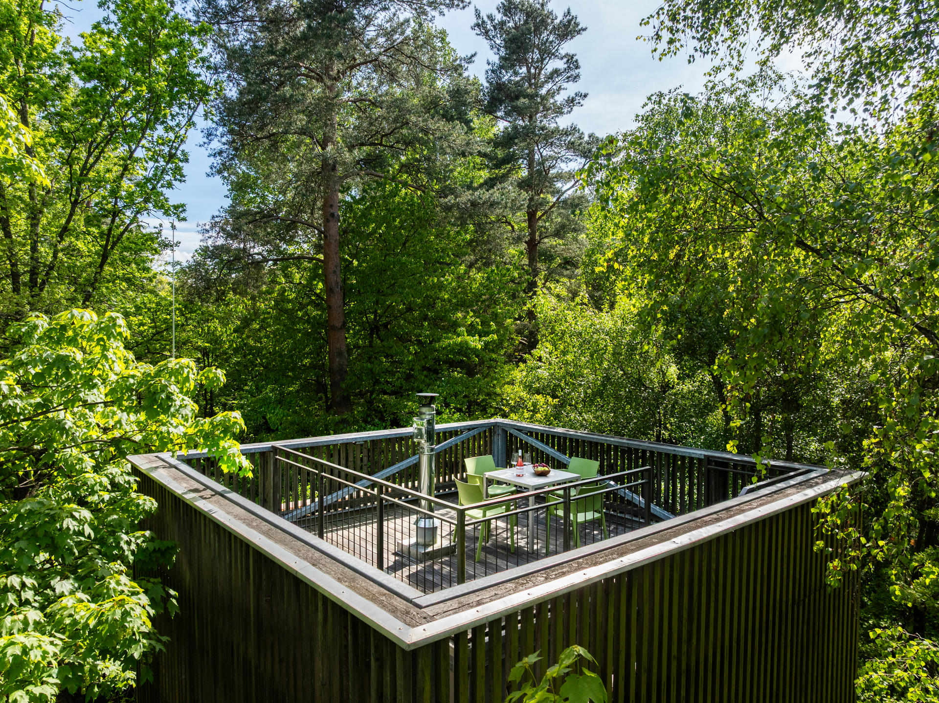 Baumhaus mit Terrasse in einem Wald.