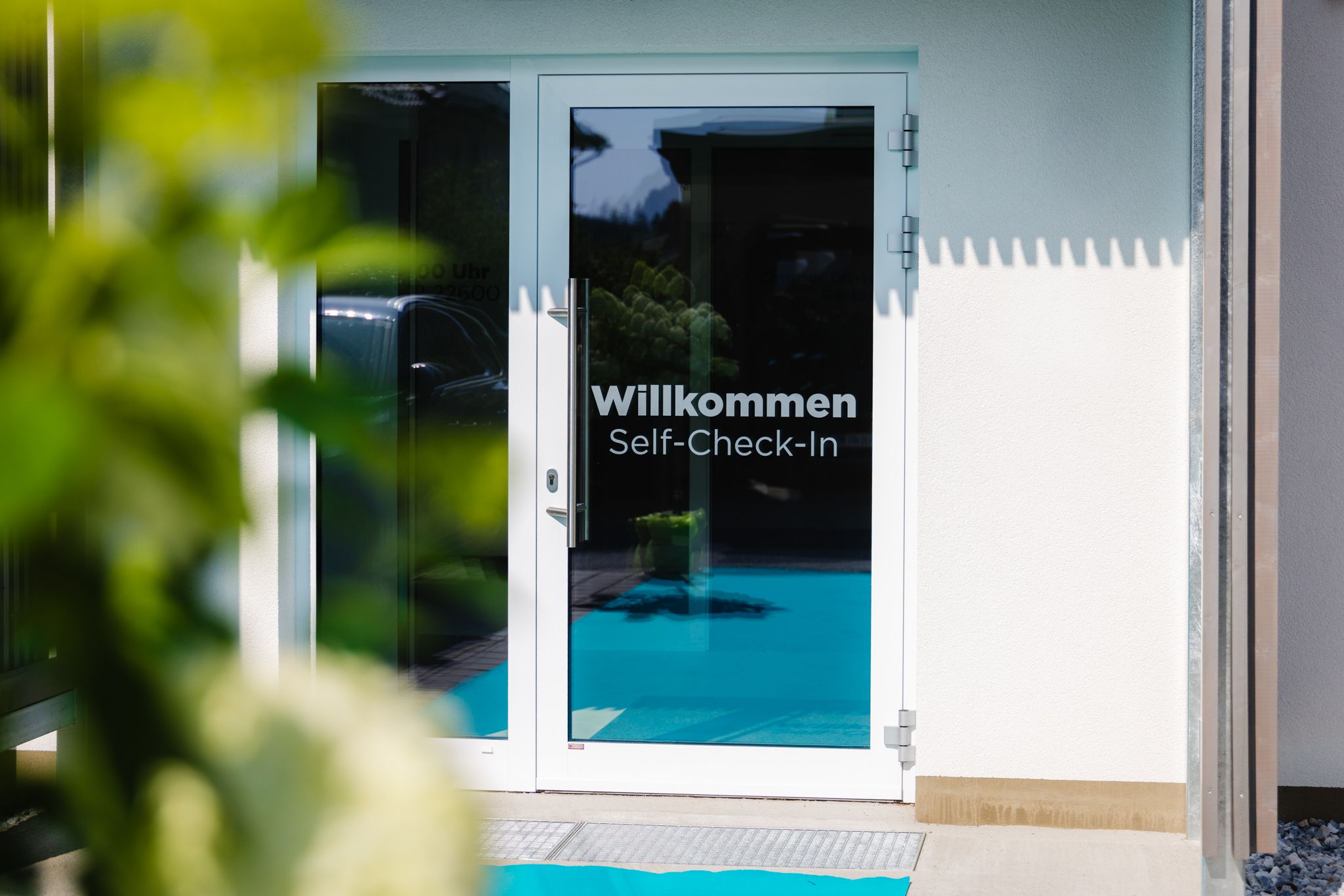 Weiße Tür mit der Aufschrift 'Willkommen Self-Check-In'.